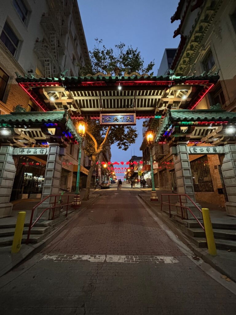 Dragon's Gate di Chinatown San Francisco - arco decorativo con porte rosse, lanterne dorate, tetto verde e motivi di dragoni che marca l'ingresso principale al crepuscolo