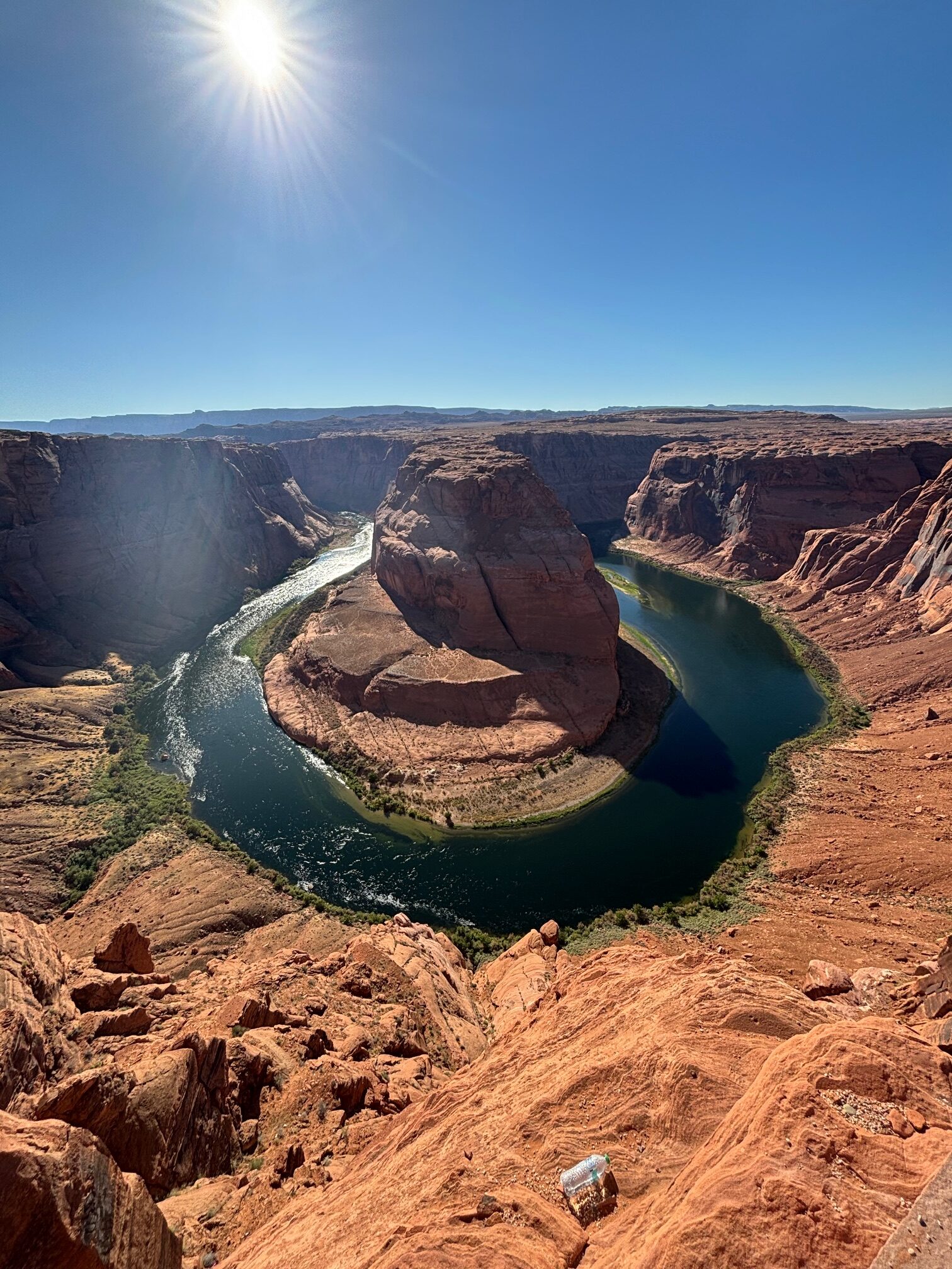 Colorado River che fa una curva a ferro di cavallo con acque turchesi circondate da rocce rosse sotto cielo azzurro