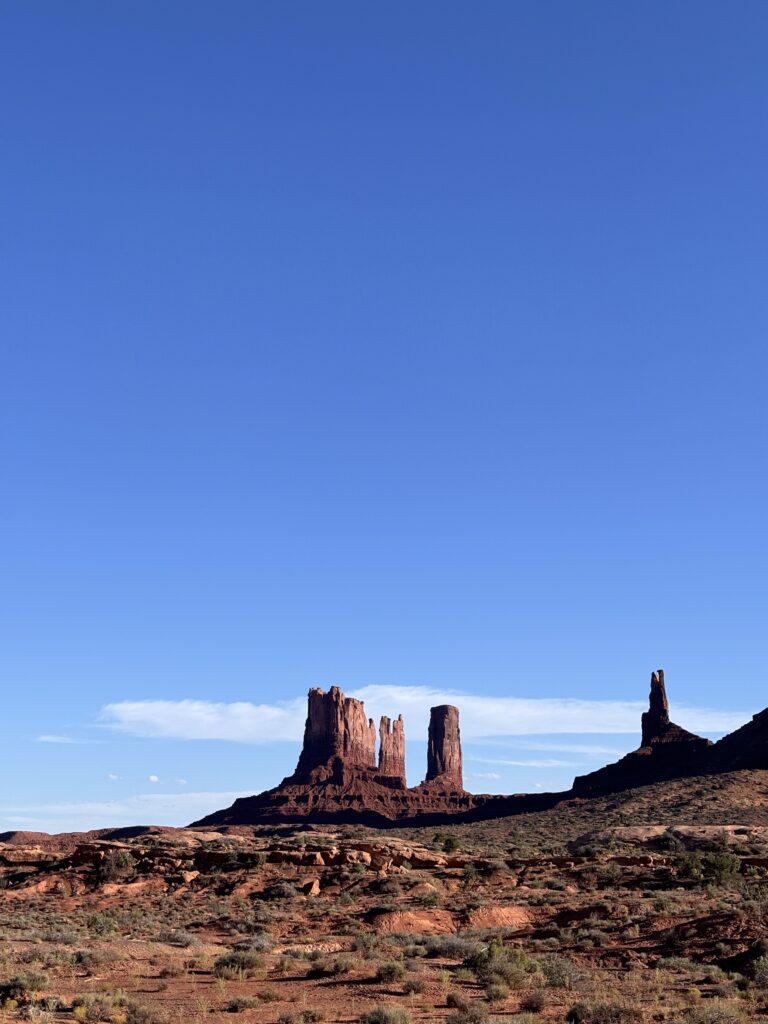 Buttes rossi di Monument Valley contro un cielo azzurro limpido nel paesaggio desertico
