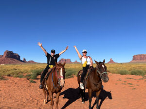 Alessia e Michael a cavallo in Monument Valley Navajo Tribal Park con buttes in arenaria rossa sullo sfondo