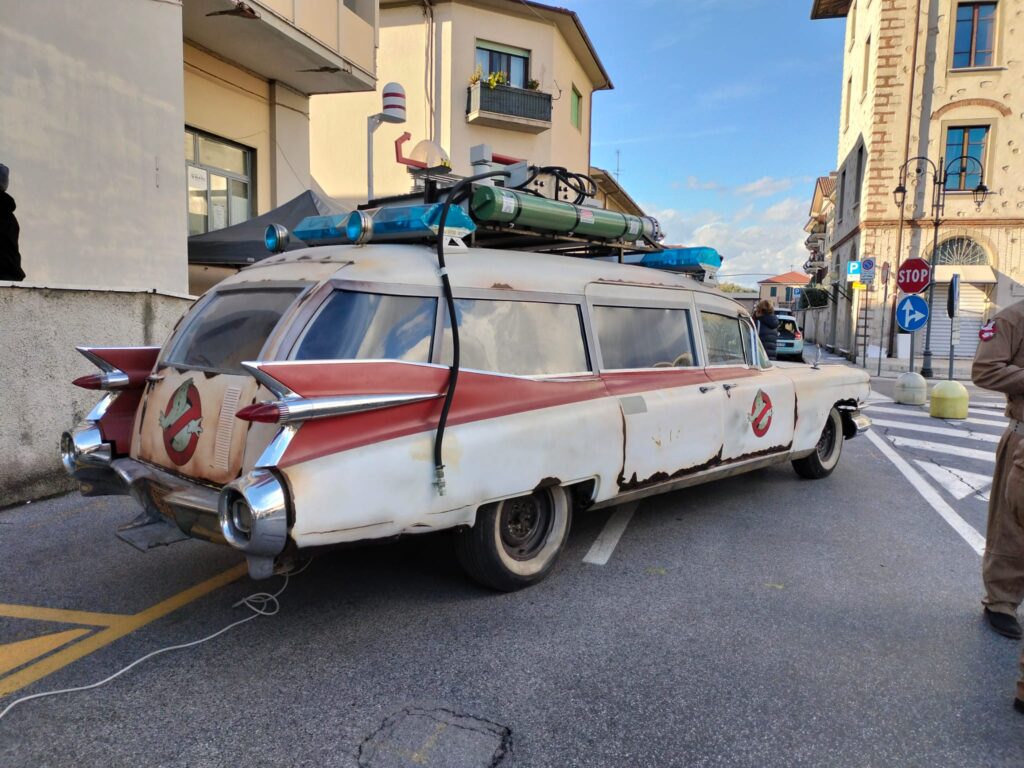 Vista posteriore della replica completata della Ecto-1 Italiana, parcheggiata su strada, che mostra i dettagli effetto ruggine e il logo Ghostbusters sul portellone.